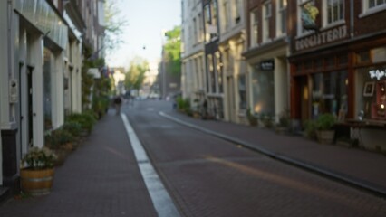 Blurred view of a quiet european city street with defocused buildings and indistinct pedestrian under soft daylight, creating a serene bokeh effect in an outdoor urban setting.
