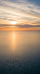 Obraz premium Serene ocean sunset with golden light reflecting on the water
