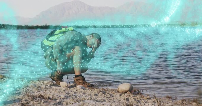 Hiker crouching touching stone initiating glowing energy ribbon wrapping torso for technology demo