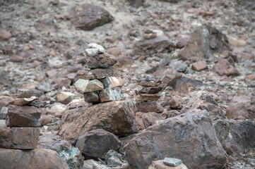 Neatly stacked stone cairns in the remote Himalayan wilderness of Ladakh, India. Traditional cairns symbolize guidance, meditation, and spirituality, set against rugged mountain landscapes. 