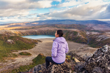 Beautiful asian woman enjoying with Tama Lakes viewpoint and Mount Ruapehu hiding in the cloud on summit at Tongariro national park, New Zealand