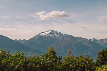 Clouds over the mountains with trees in the foreground