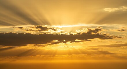 Fototapeta premium Brilliant golden sunbeams radiate from behind dark clouds in a dramatic, awe-inspiring sky at sunset.