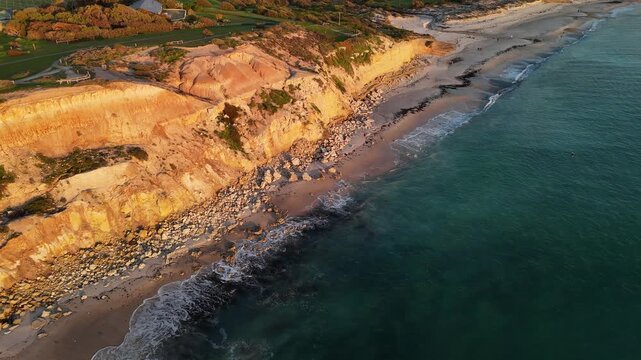 Port Willunga Beach, South Australia: 4K Aerial Drone Footage of Golden Cliffs, Golden Sand beach, Farmland Hills, Coastal Houses, Ocean Waves and Sunset Views