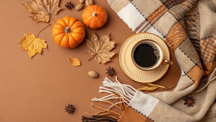 Fototapeta premium Autumn Top View: Gilded Coffee Cup with Scarf and Pumpkin Candles on Brown Background