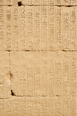 Dendera, Egypt- August 13, 2025: Background of bas-relief in a Temple of Hathor at Dendera Temple complex. 
