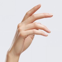 Graceful hand poised with delicate fingers extending gently against a plain light background capturing elegance and fine skin texture in soft natural lighting close-up view