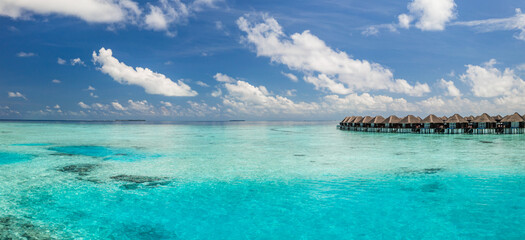 Amazing Maldives resort water villas aerial landscape sunny tropical island blue sea stunning scenic background summer vacation paradise luxury travel destination tourism escape. Tranquil paradise