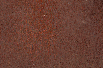 A macro shot of a granular rust texture, showing fine powdery layers of oxidation and a visual mosaic of deep orange and brown tones.