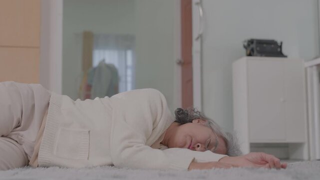 An elderly Asian female patient fainted and fell to the floor at home and was helped charming physical therapist nurse in living room. High or low blood pressure, diabetes, heart disease. Older care.