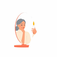 Young woman looking in mirror while holding candle thoughtfully  