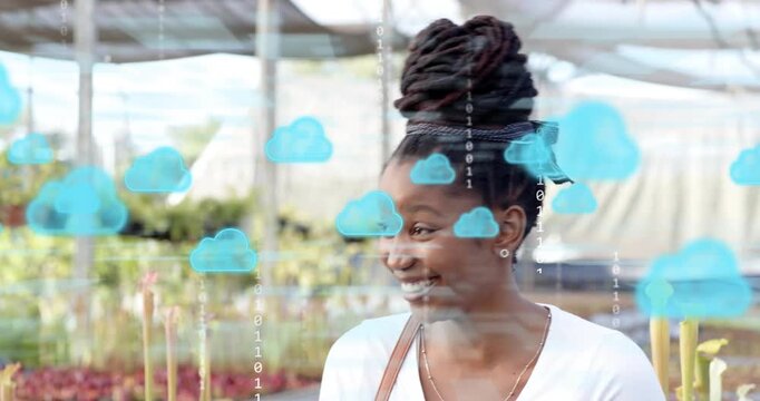 Woman shifting gaze in nursery activating cloud icons with drifting data showcasing technology
