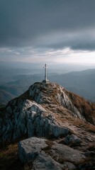 Fototapeta premium Cross atop mountain peak in mist