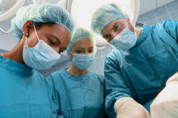 Focused Team of Diverse Surgeons Performing Precision Surgery in Brightly Lit Operating Room