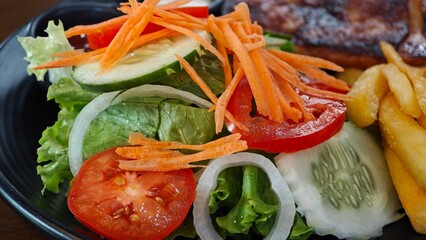 Chicken steak with salad, french fries, ketchup and mayonnaise.