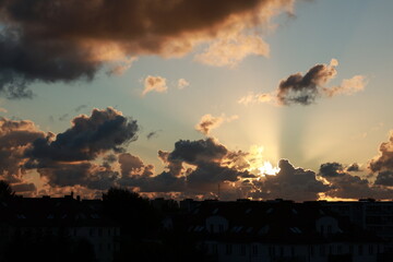 Sunbeam breaks through black clouds at sunset