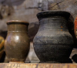 Antique cast iron pot on a wooden shelf.