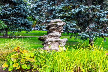 Strange stone rock monument sculpture statue in green park garden.