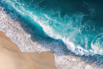 Minimalist aerial view showcasing the vibrant blue ocean wave rolling onto a sandy beach under bright sunlight during the day