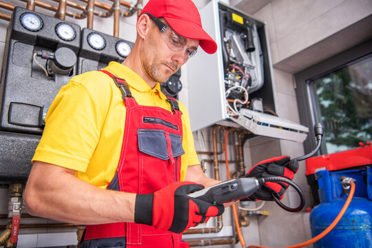 Technician Performing Maintenance on Heating Equipment in a Utility Room