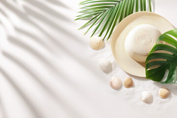 Tropical beach scene with straw hat, seashells, and palm leaves on soft white sand