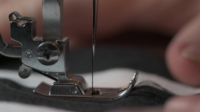 Close-up of sewing machine needle stitching fabric in a well-lit workshop during afternoon hours
