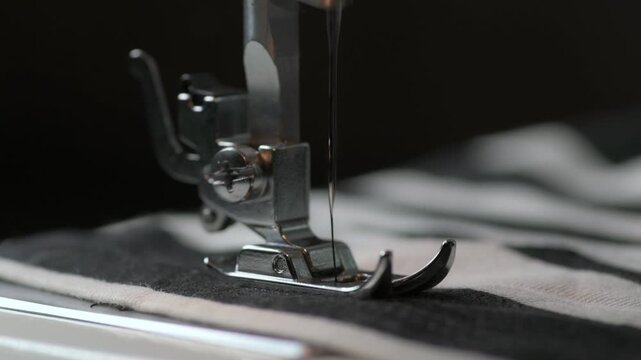 Close-up view of sewing machine in action during garment creation in a cozy workshop environment