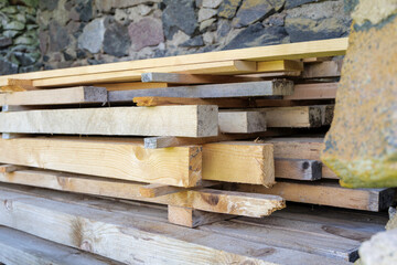 Stacked Wood Planks by a Stone Wall