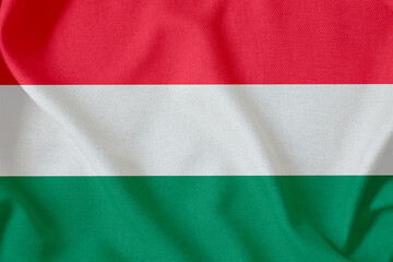 Obraz premium flag of the Republic of Hungary with three horizontal stripes on a rough canvas with folds