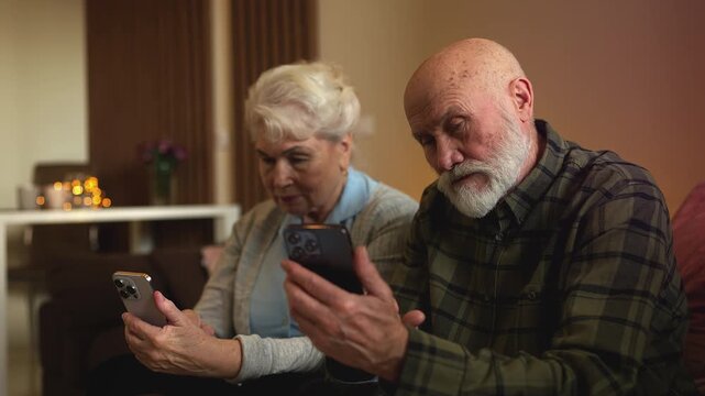 Elderly husband and wife scrolling phones together at home, gadget addiction