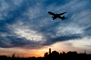 美しい太陽・光・雲・空を背景に飛ぶ航空機