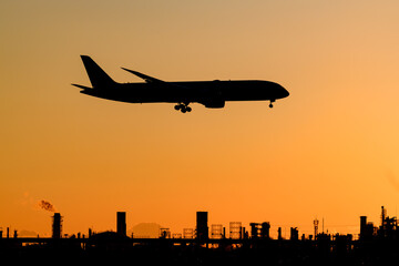 美しい太陽・光・雲・空を背景に飛ぶ航空機