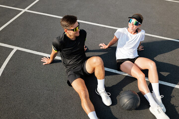 Energetic friends enjoy a break on the court after an intense basketball practice session