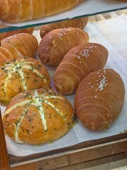 Korean Cream Cheese Garlic Bread and Shio pan, or Japanese salt bread, behind a displayed mirror.