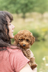 Porträt einer Frau mit ihrem Zwergpudel Welpen