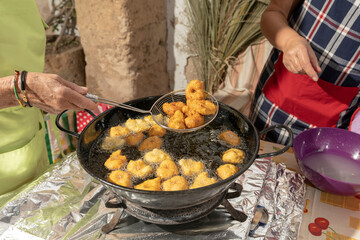 Frying Mallorcan potato and sweet potato fritters