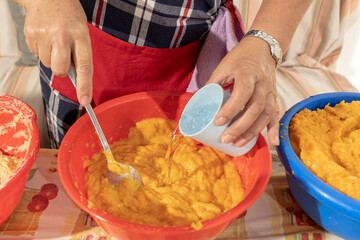 Adding water to a flour, potato and sweet potato dough to make fritters. Bunyols, typical food of Mallorca