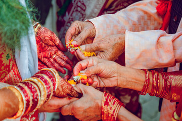 Bride receiving flower petals during traditional hindu wedding ceremony