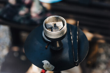 Photo of smoldering coals in a round bowl in an outdoor hookah design.