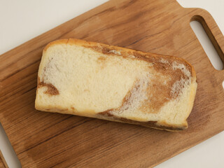 Loaf bread with cream filling on wooden cutting board