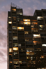 Gray apartment building facade with windows at night