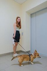 woman and her dog are waiting for the elevator to go for a walk