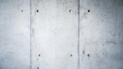 Soft lighting highlighting concrete wall's textured surface, revealing subtle pitted patterns against neutral background