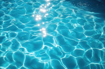 Sunlight sparkling and shimmering on the clear blue surface of a swimming pool with gentle water ripples and reflections