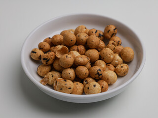 Fried coated peanut on white bowl