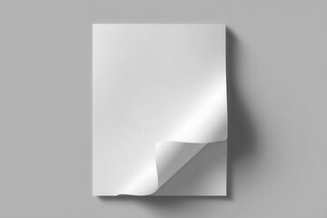 Realistic blank white paper page with shadow on a grey surface, showcasing a curled corner for artistic and design purposes