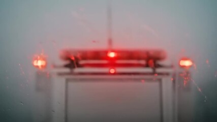 Emergency vehicle with flashing lights in foggy conditions, signaling urgency on a dimly lit road