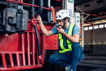 Engineer railway wearing safety uniform and helmet under checking under train ,wheels and control system for safety travel passenger. Banner cover design.