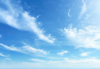 Obraz premium Bright blue sky with scattered wispy white clouds creating a peaceful and uplifting atmosphere