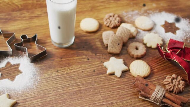 Christmas decorations with an assortment of cookies and glass of milk on wooden background